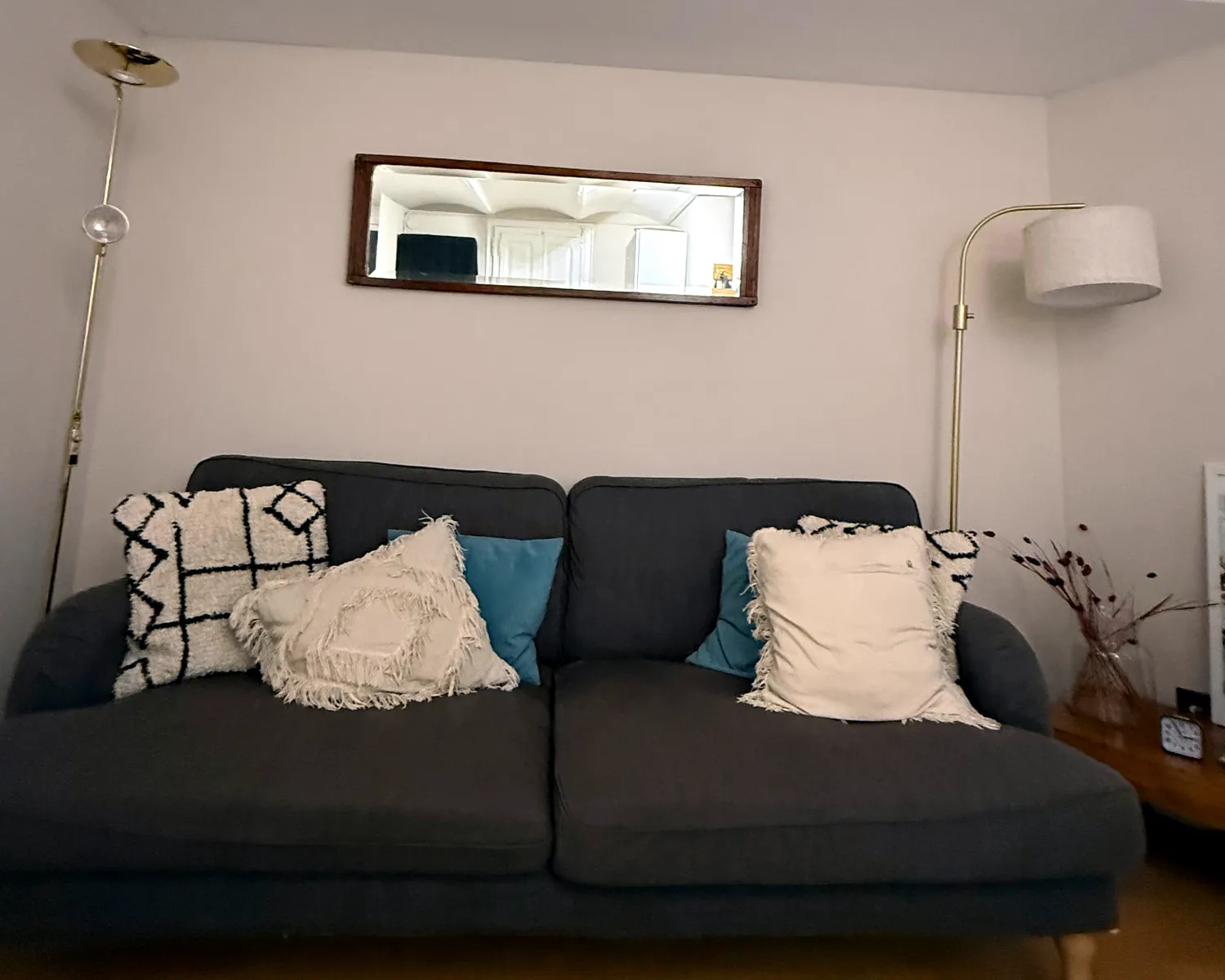 Sala de espera con sofá gris y cojines